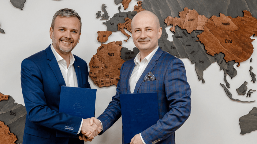 Grzegorz Mazurek i Radosław Maćkiewicz podają sobie ręce i trzymają umowę o współpracy